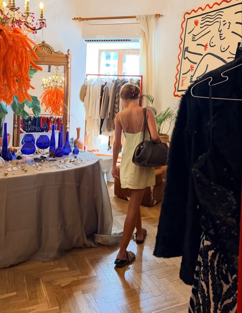 A shopper beside jewellery and colourful glassware